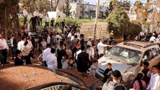 Warga berkumpul untuk melihat kerusakan setelah Iran melancarkan serangan rudal di Bnei Brak, Israel, Minggu (8/3/2026). (REUTERS/Tomer Appelbaum)